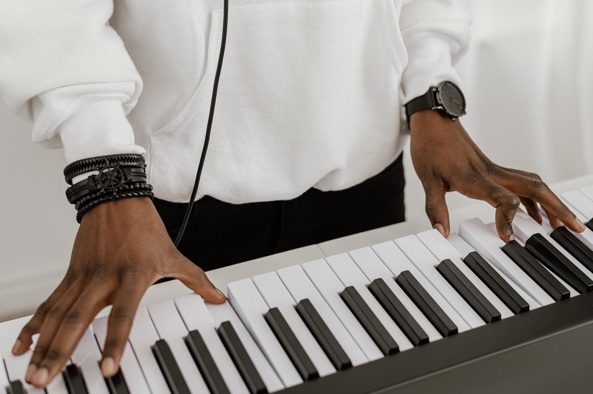 Piano digital ou acústico: qual a melhor escolha para seu estilo? 3 Alto ângulo de músico tocando teclado elétrico