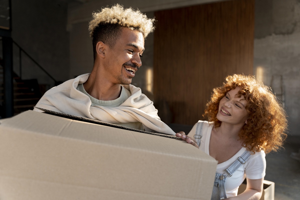 Casal com caixas de papelão para sua mudança